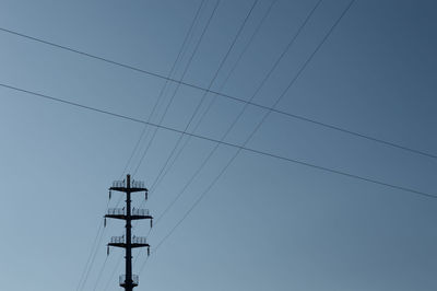 Power lines against clear blue sky