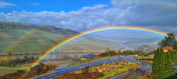 Rainbow over landscape against sky