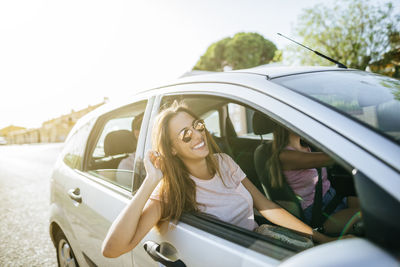 Happy friends in car seen from outside