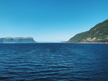 In the middle of a fjord in norway, infinity and immensity, horizon over the sea on a sunny day