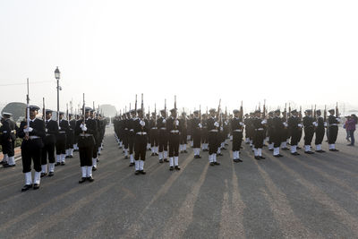 Group of people in row against clear sky