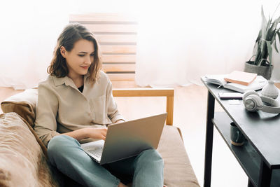 Young woman using laptop at home