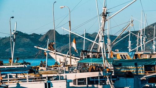 Sailboats moored at harbor against clear blue sky