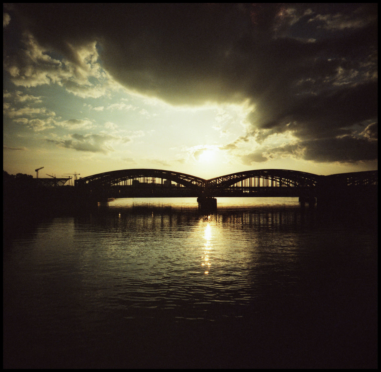 ARCH BRIDGE OVER RIVER AGAINST SKY DURING SUNSET