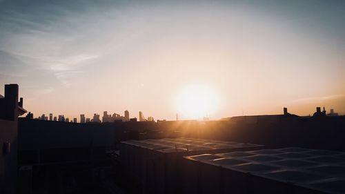 Silhouette buildings against sky during sunset