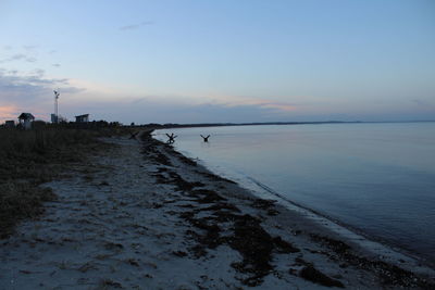 Scenic view of beach against sky during sunset