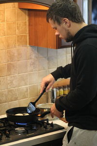 Side view of man preparing food at home