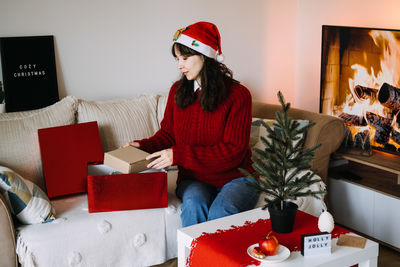 Portrait of woman using digital tablet while sitting on sofa at home