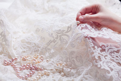 Cropped hands of woman stitching wedding dress