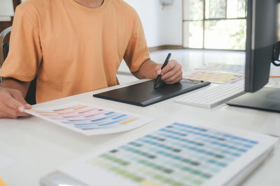 Midsection of man using laptop on table