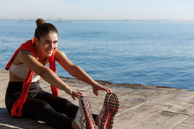 Woman exercising by sea