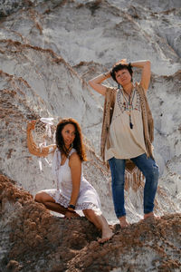 Full length of young woman sitting on rock