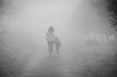 Full length of man on landscape in foggy weather