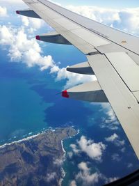 Cropped image of airplane flying over clouds