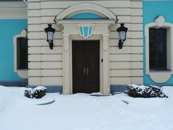Snow covered blue house with close door