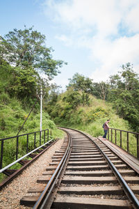 Man standing by railway track against sky