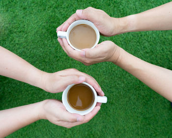 Low section of woman holding coffee cup