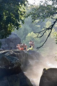 People on rocks against mountain