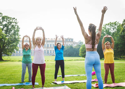 Rear view of woman doing yoga at park