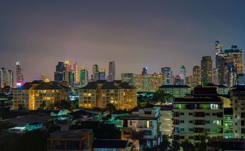 Illuminated buildings in city against sky at night