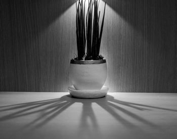 Close-up of lamp on table against wall at home
