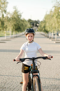 Girl 11 years old in the park with a bicycle. children's sports and a healthy lifestyle.