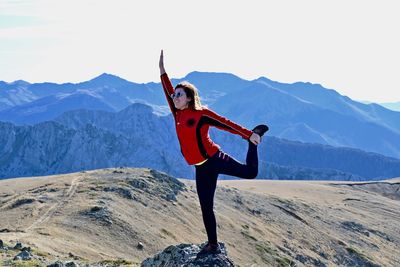 Woman standing in front of mountains against sky