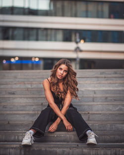 Portrait of young woman sitting outdoors