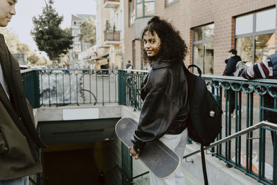 Young friends standing on steps in city