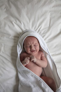 High angle view of baby sleeping on bed