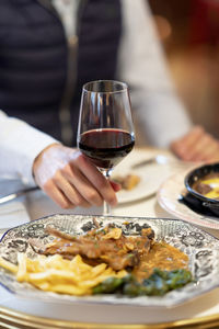 Midsection of person holding ice cream in plate on table