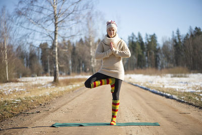 Young attractive woman practicing yoga on the rural road.outdoor activity. practice yoga asana. 
