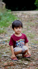 Portrait of boy sitting on field