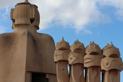 Low angle view of statues against building against sky