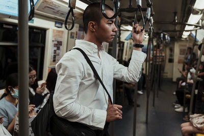 Side view of young man looking at city