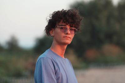 Portrait of young man wearing sunglasses standing outdoors