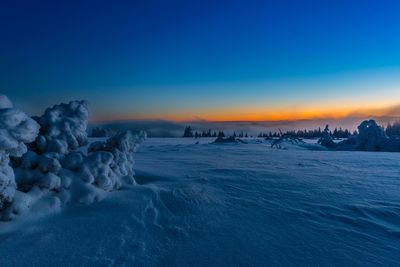 Scenic view of frozen lake against sky during sunset