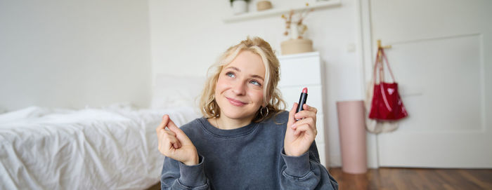 Portrait of young woman using mobile phone at home