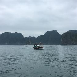 Boat sailing on sea against sky