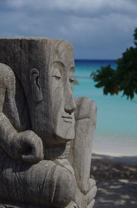 Close-up of statue against sky and lagoon