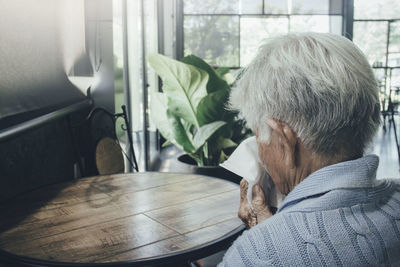 Rear view of man on table at home