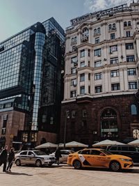 Cars on road by buildings in city