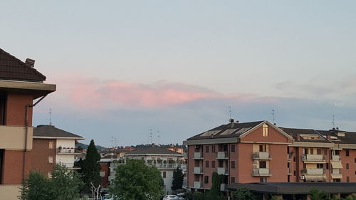 Houses and buildings against sky during sunset