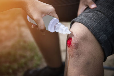 Low section of man holding bottle