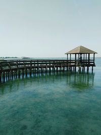 Pier on sea against clear sky