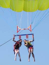 Low angle view of people against clear blue sky
