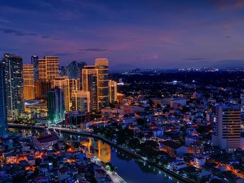 High angle view of illuminated buildings against sky at dusk