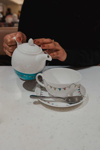 Man holding coffee cup on table