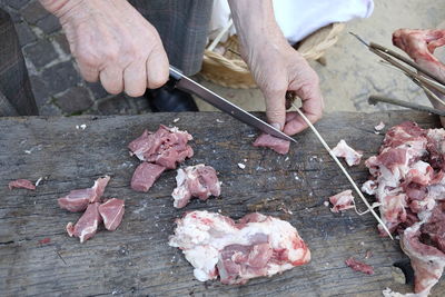 High angle view of butcher cutting meat on wood