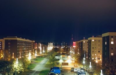 High angle view of illuminated buildings against sky at night